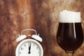 Toast stout beer glass and white vintage alarm clock close-up Royalty Free Stock Photo