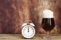 Toast stout beer glass and white vintage alarm clock Royalty Free Stock Photo