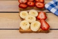 Toast with strawberries and bananas on a wooden background Royalty Free Stock Photo