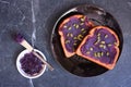 Toast with ube halaya jam and pumpkin seeds. Table scene on a dark slate background. Royalty Free Stock Photo