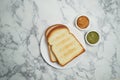 Top view Toasted bread with butter, kaya, jam, peanut butter on marble table