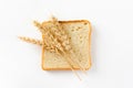 Toasted bread sliced into slices and ears of wheat on a white background. Royalty Free Stock Photo