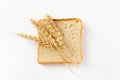 Toasted bread sliced into slices and ears of wheat on a white background. Top view, flat lay Royalty Free Stock Photo