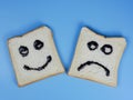 toasted bread with smiley and sad emoticons, for the concept of happiness and sadness