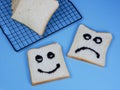 toasted bread with smiley and sad emoticons, for the concept of happiness and sadness