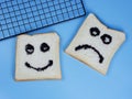 toasted bread with smiley and sad emoticons, for the concept of happiness and sadness