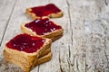 Toasted cereal bread slices with homemade cherry jam closeup on rustic wooden table background Royalty Free Stock Photo