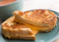 Grilled cheese sandwich on a small plate. Bowl of tomato bisque soup in the background. Royalty Free Stock Photo