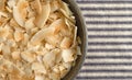 Toasted coconut flakes in a bowl on a tablecloth