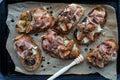 Toasted fig and prosciutto tartines on a parchment lined baking sheet. Royalty Free Stock Photo
