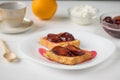 Toasted French bread, plum jam, cottage cheese and orange on a white wooden table. Royalty Free Stock Photo