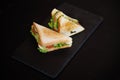 Toasted Sandwich With Lettuce, Tomato, Cheese and Ham, Triangular Slices on Slate Surface Royalty Free Stock Photo