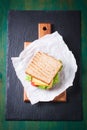 Toasted sandwich with salad leaves, tomatoes and cheese with fork on a cutting board Royalty Free Stock Photo