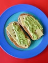 Toasted sourdough ciabatta bread with slices of Swiss cheese and guacamole on a plate