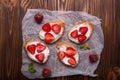 Toasts or bruschetta with strawberries on cream cheese on white wooden background. Royalty Free Stock Photo