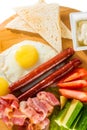 Toasts, fried eggs, sausages, meat and vegetables