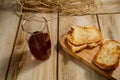 Toasts with sausage and cheese on a wooden stand and a glass of natural juice. The concept of tasty and natural food. Royalty Free Stock Photo