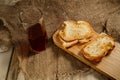 Toasts with sausage and cheese on a wooden stand and a glass of natural juice. The concept of tasty and natural food. Royalty Free Stock Photo