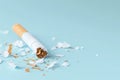 Tobacco Relinquished: Squashed Cigarette on Soft Blue.