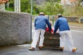 Toboggan riders moving cane sledge downhill on the streets of Funchal, Madeira island Royalty Free Stock Photo