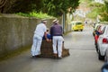 Toboggan riders moving cane sledge downhill on the streets of Funchal, Madeira island Royalty Free Stock Photo