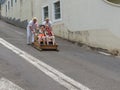 Toboggan riders moving cane sledge downhill on the streets of Funchal Royalty Free Stock Photo