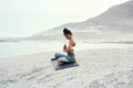 Today is all about restoring a great sense of calm. a sporty young woman practicing yoga at the beach.