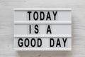 `Today is a good day` words on a lightbox on a white wooden background, top view. Overhead, from above, flat lay. Close-up