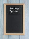 Today`s Specials - words in white chalk on a blackboard isolated on blue wood Royalty Free Stock Photo