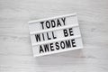 `Today will be awesome` words on a lightbox over white wooden background, overhead view. Flat lay, from above, top view