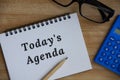Today's agenda text on notepad. Glass, pencil and calculator background. Royalty Free Stock Photo