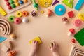 Toddler activity for motor and sensory development. Baby hands with colorful wooden toys on light table top view Royalty Free Stock Photo