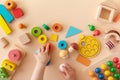 Toddler activity for motor and sensory development. Baby hands with colorful wooden toys on table from above Royalty Free Stock Photo