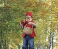 Toddler with apple and bakset,, outdoors