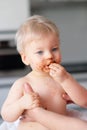 Toddler baby boy child eating fruit with dirty messy face Royalty Free Stock Photo