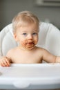 Toddler baby boy child eating fruit with dirty messy face Royalty Free Stock Photo