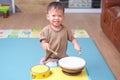 Toddler baby boy child hold sticks & plays a musical instrument drum