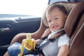 Toddler baby boy child sitting in safety carseat holding & enjoy eating banana Royalty Free Stock Photo