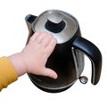 Toddler baby boy holds a hot kettle with boiling water, isolated on a wh Royalty Free Stock Photo