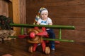 Toddler baby boy is playing in a large wooden plane. Royalty Free Stock Photo