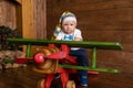 Toddler baby boy is playing in a large wooden plane. Royalty Free Stock Photo