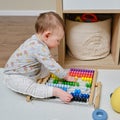 Toddler baby boy plays with his hands with colorful abacus on the floor, child with a toy in rainbow colors Royalty Free Stock Photo