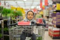 Toddler baby boy, sitting in a shopping cart in grocery store, s Royalty Free Stock Photo