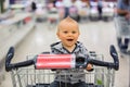 Toddler baby boy, sitting in a shopping cart in grocery store, s Royalty Free Stock Photo