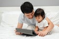 toddler baby with father looking digital tablet pc on bed Royalty Free Stock Photo