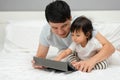 toddler baby with father using digital tablet pc on bed Royalty Free Stock Photo