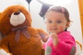 Toddler baby girl playing with big teddy bear Royalty Free Stock Photo