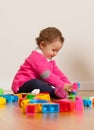 Toddler baby girl playing with rubber building blocks. Royalty Free Stock Photo