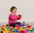 Toddler baby girl playing with rubber building blocks. Royalty Free Stock Photo