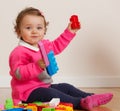 Toddler baby girl playing with rubber building blocks. Royalty Free Stock Photo